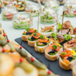 An array of elegant cocktails and gourmet canapés beautifully presented on a catering table.